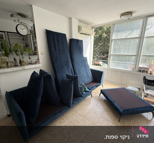 ספת בד כחולה בסלון הבית במהלך או בתום תהליך ניקוי